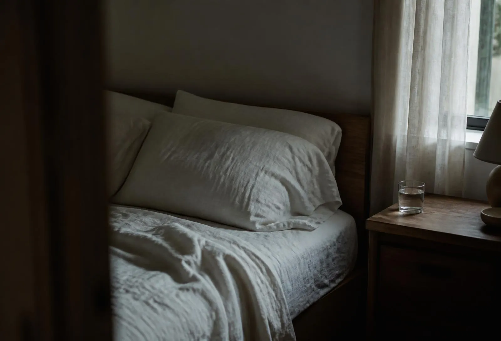 A single armchair beside a side table and unlit brass lamp.
